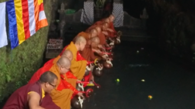 Para Bhikkhu sedang mengambil air suci di Umbul Jumprit, Temanggung