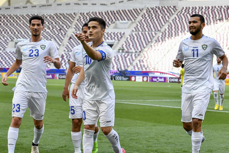 Pemain Uzbekistan Khusayin Norchaev merayakan golnya