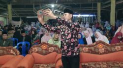 Wabup Bima dr.Irfan Zubaidy berswafoto menggunakan gawai warga saat pembukaan MTQ XI Kec.Parado Bima. (Foto;MDA)